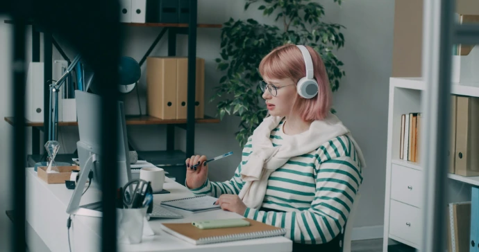 A woman sitting at a desk with headphones on